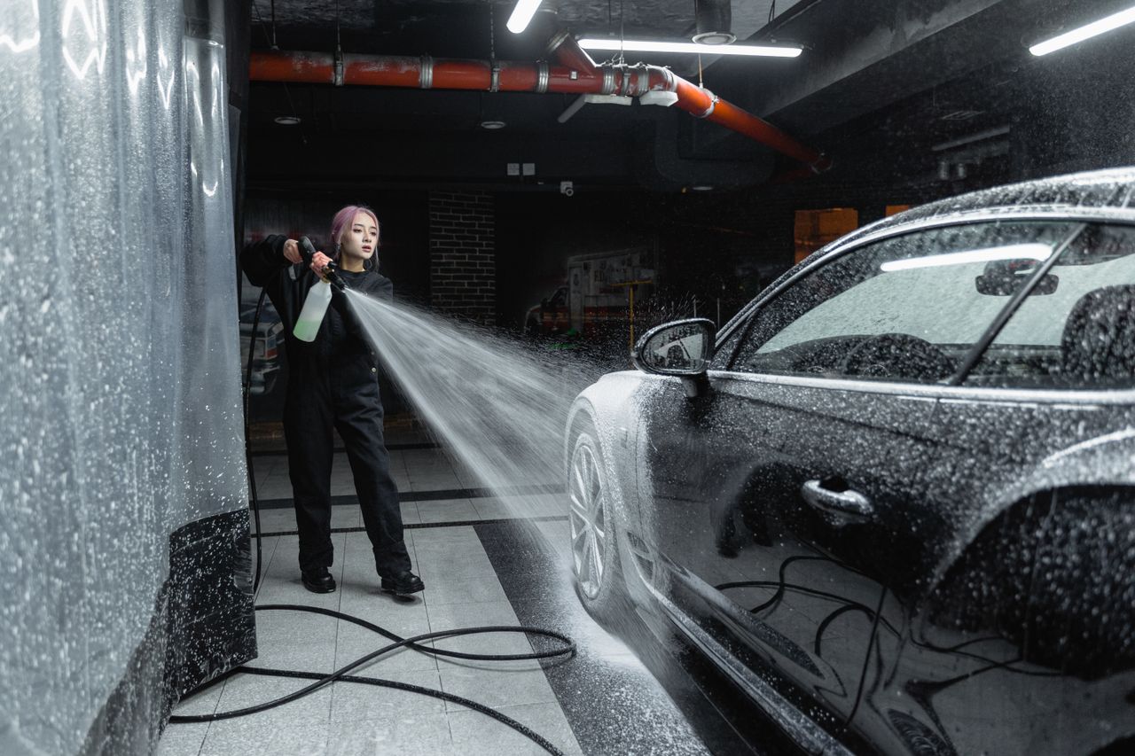 Woman using a pressure washer for a trusted car wash